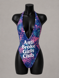 Colorful swimsuit with 'Anti Broke Girls Club' text on a mannequin against a gray background