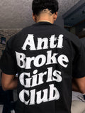 Person wearing a black t-shirt with 'Anti Broke Girls Club' text on the back.
